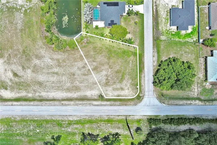 Aerial view of property and surrounding area featuring a large body of water and property boundaries highlighted