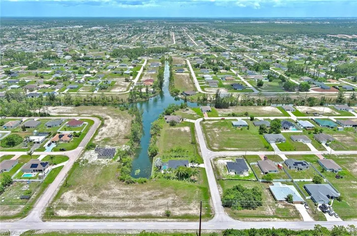 Aerial view of property and surrounding area with nearby suburban area and a nearby body of water