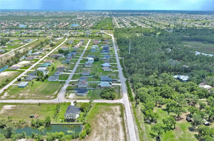 Aerial view of property and surrounding area featuring a large body of water and nearby suburban area