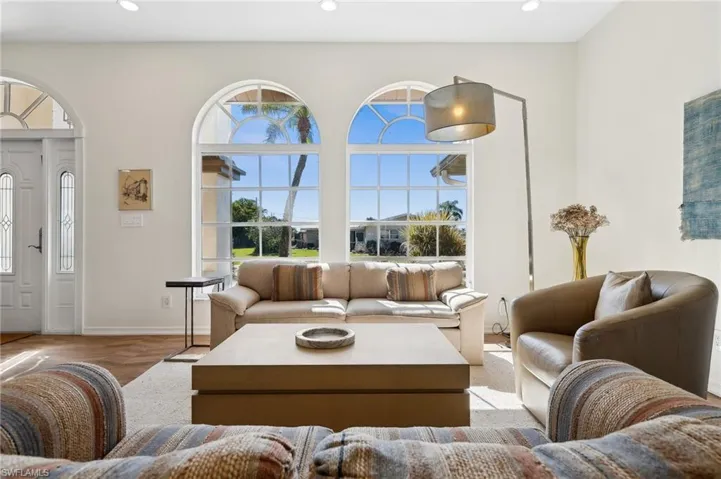 Large arched windows frame peaceful outdoor views.