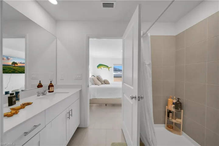 Bedroom with light tile patterned floors and ensuite bathroom