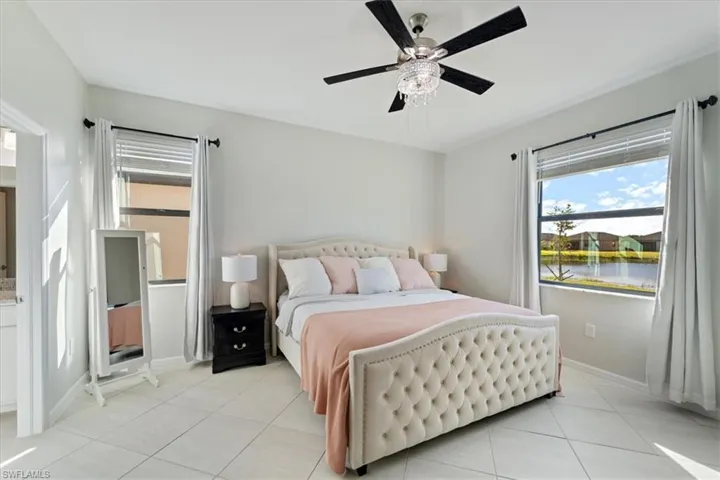 Light-filled interior featuring tile flooring, a decorative ceiling fan, and crown molding