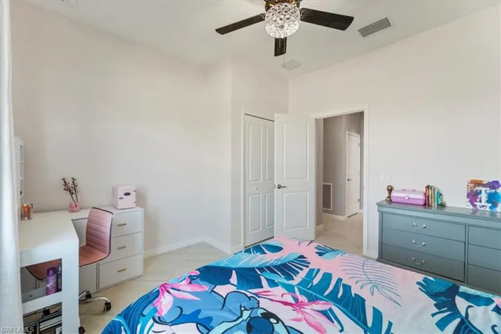 Light-toned walls with a vaulted ceiling and a ceiling fan featuring a decorative light fixture