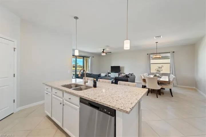 Kitchen island with granite countertop, double stainless steel sink, and integrated dishwasher