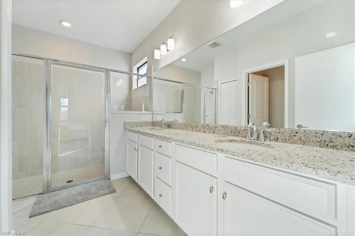 Dual vanity with granite-style countertops and white cabinetry