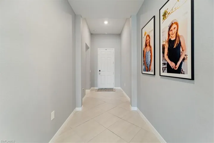 Entryway featuring a white paneled door, recessed lighting, and light-toned diagonal tile flooring