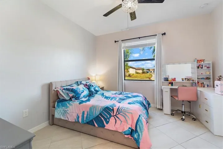 Bedroom featuring a single window with blinds and drapes, a ceiling fan with light fixture, and tile flooring