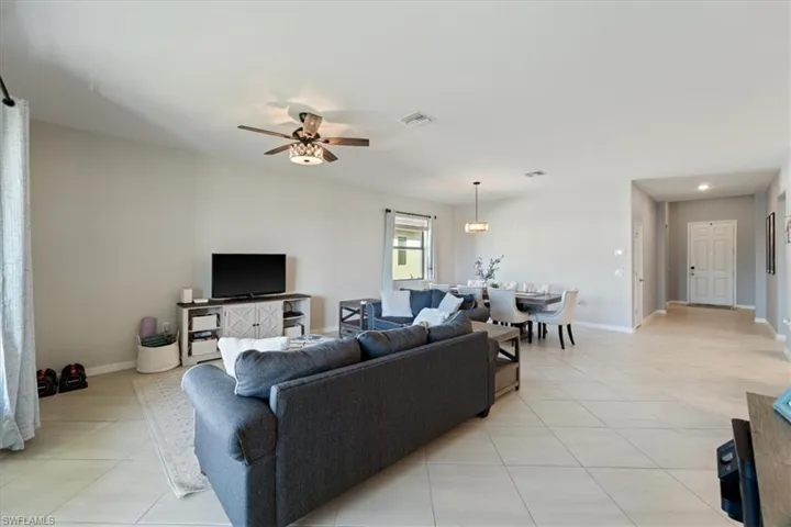 Open-concept living space featuring light-toned tile flooring, a contemporary ceiling fan, and recessed lighting