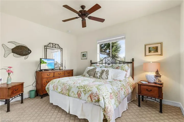 Bedroom with ceiling fan and light colored carpet