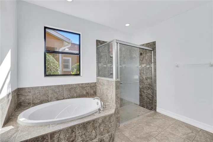 Bathroom featuring separate shower and tub and tile patterned flooring