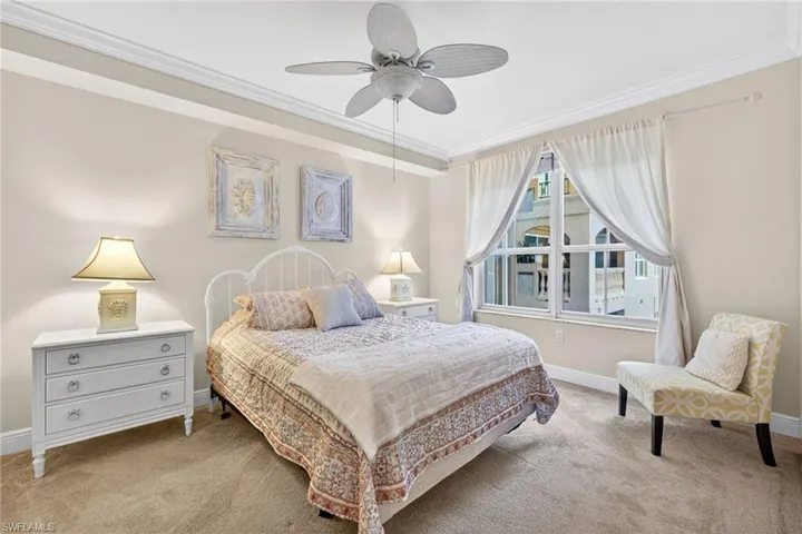 Carpeted bedroom with crown molding and ceiling fan