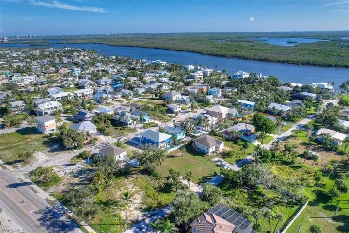 Aerial overview of property's location featuring property parcel outlined and waterfront with a beach