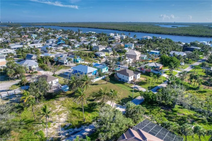 Aerial view of property and surrounding area featuring a large body of water and nearby suburban area