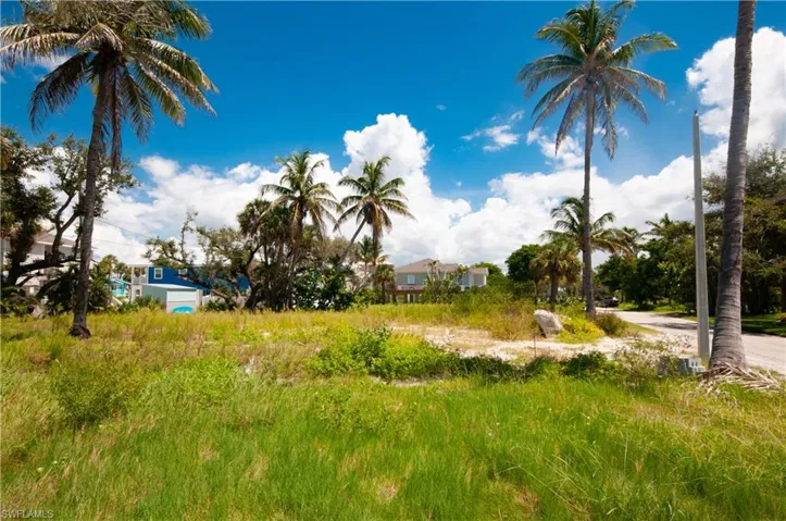 Aerial perspective of suburban area featuring property parcel outlined and a nearby body of water