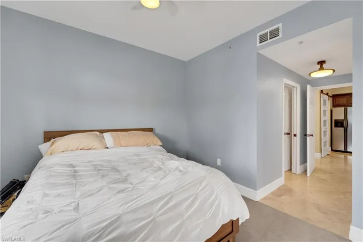 Bedroom featuring stainless steel fridge and a ceiling fan