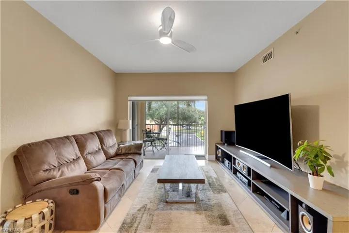 Living area with ceiling fan and light tile patterned floors