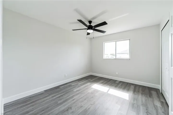 Unfurnished bedroom with ceiling fan and hardwood / wood-style floors