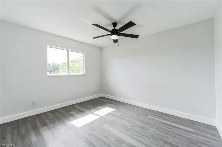 Spare room featuring wood-type flooring and ceiling fan