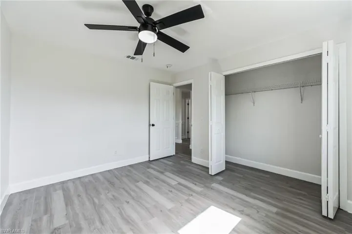 Unfurnished bedroom featuring ceiling fan, a closet, and hardwood / wood-style flooring