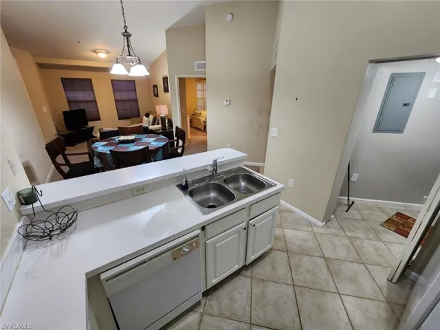 Kitchen with dishwasher, light countertops, electric panel, white cabinetry, and light tile patterned floors