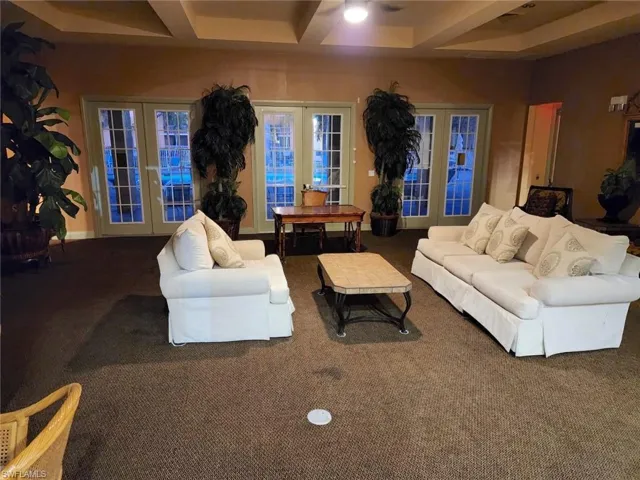 Carpeted living room with french doors