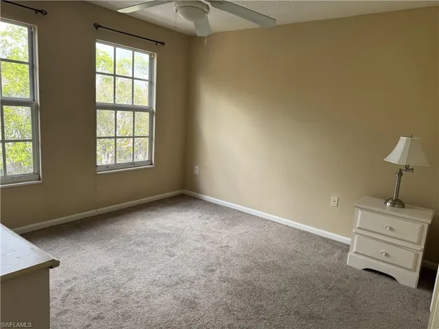 Unfurnished bedroom with light colored carpet and ceiling fan