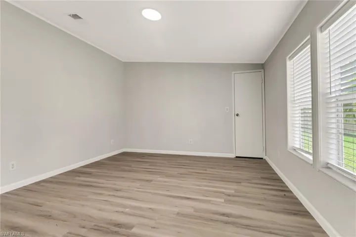 Spare room featuring ornamental molding and light hardwood / wood-style flooring