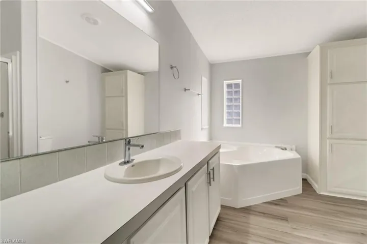 Bathroom featuring a washtub, vanity, and hardwood / wood-style flooring