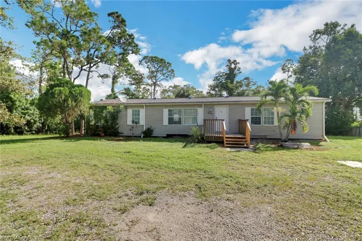 View of front of home with a front yard and a wooden deck