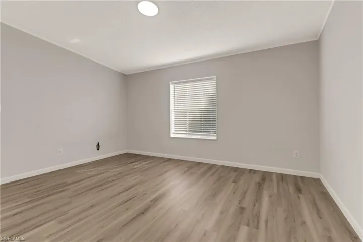 Empty room featuring crown molding and light hardwood / wood-style flooring