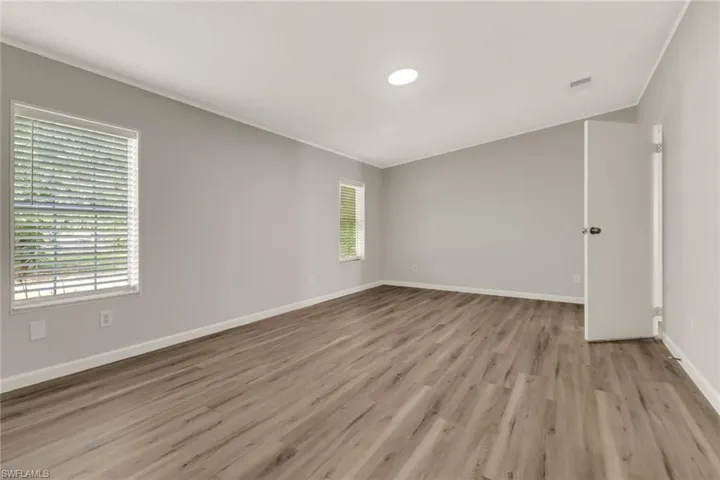 Empty room featuring light wood-type flooring and ornamental molding