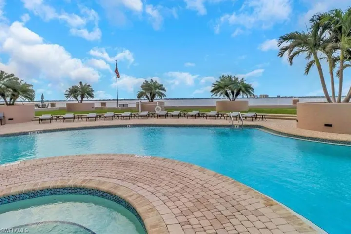 Community pool with a patio area and a hot tub