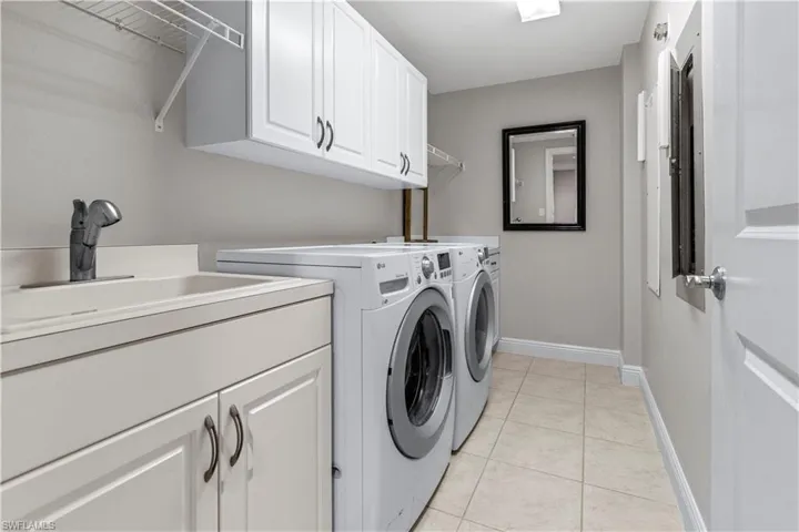 Laundry area with additional cabinet space and sink