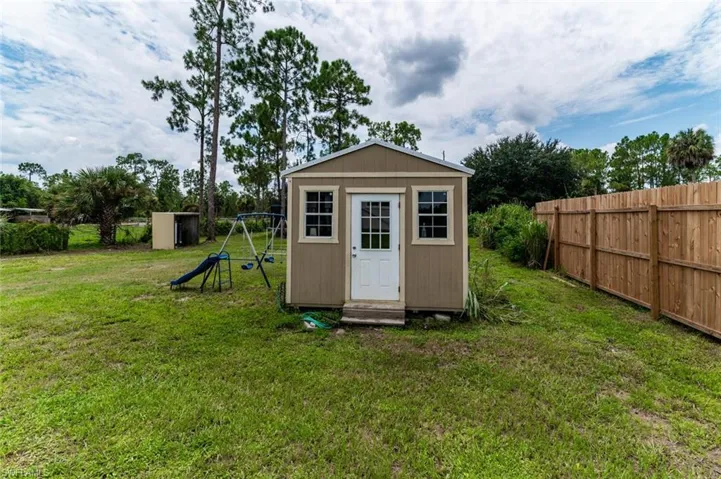 View of outdoor structure with a yard