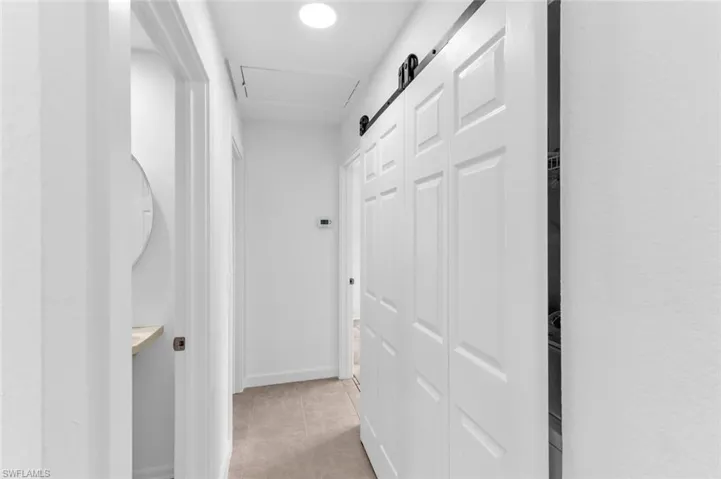 Hall featuring light tile patterned floors
