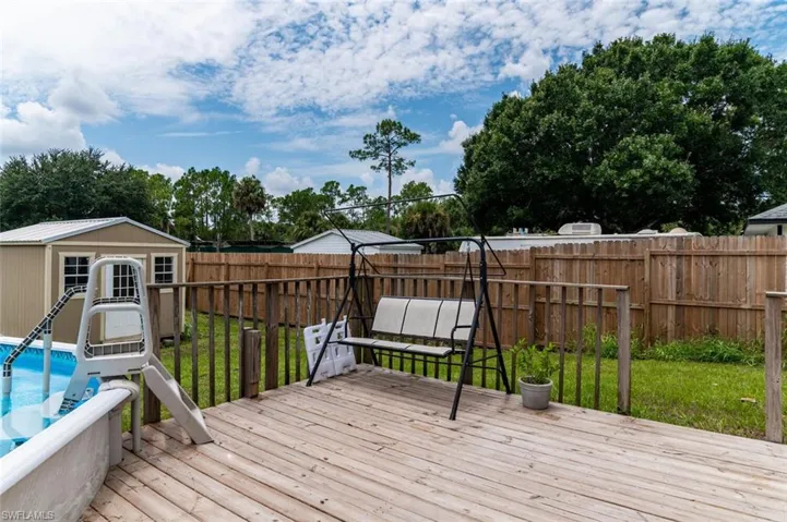 Wooden deck featuring an outdoor structure and a lawn