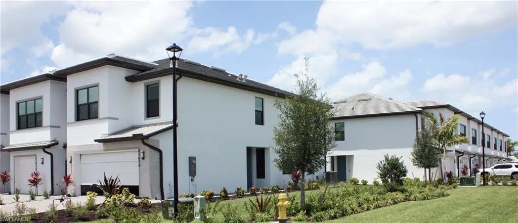 Contemporary townhome architecture featuring white stucco exteriors and dark trim