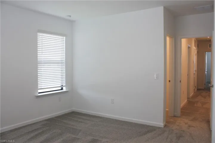 MasterBedroom Carpeted interior with neutral wall paint and a single window featuring horizontal blinds