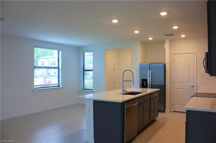 Open concept kitchen featuring an expansive island with an integrated sink and gooseneck faucet