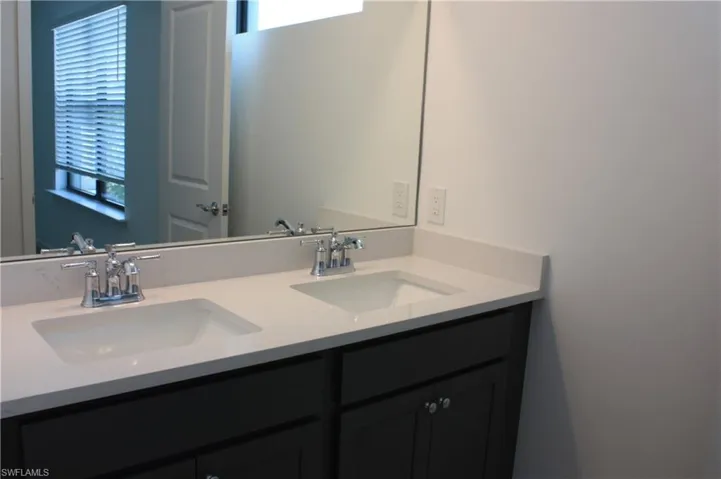 Double vanity with undermount sinks, chrome fixtures, and light-colored countertops