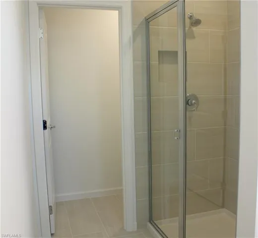 Master Bathroom Glass-enclosed shower featuring large format tile surround, an integrated shower niche, and polished chrome fixtures