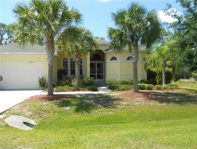 Charming front exterior framed by mature palms with a welcoming, tropical curb appeal.