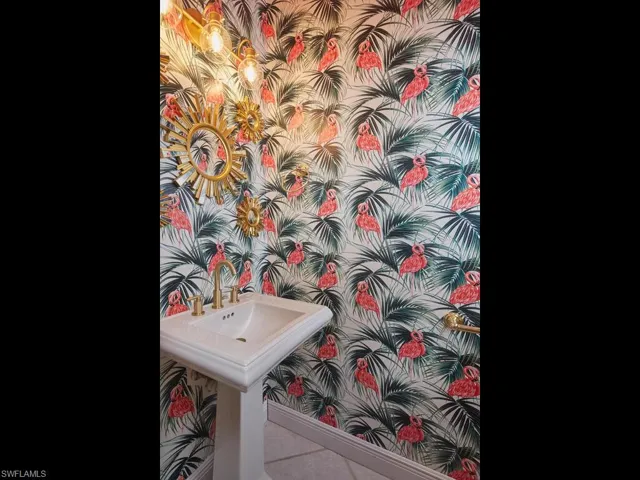 Fun and vibrant powder room with unique floral wallpaper.