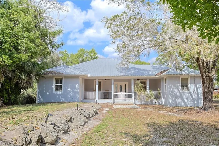 View of front facade with a porch and stucco siding