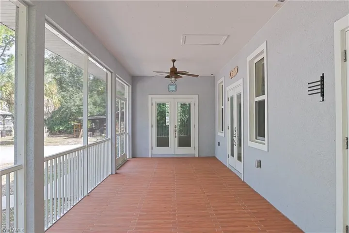 Unfurnished sunroom with french doors and a textured wall