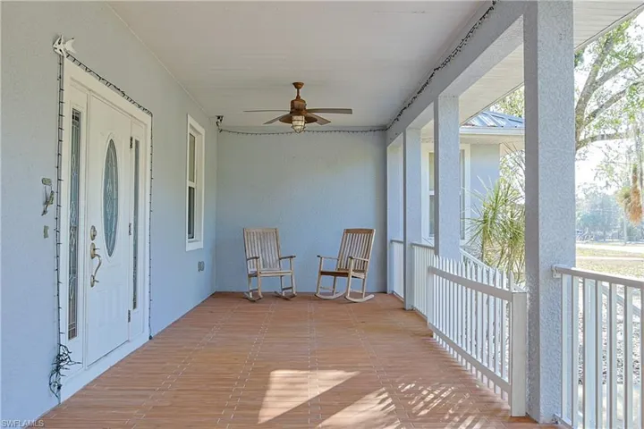 Sunroom / solarium with a ceiling fan and a porch