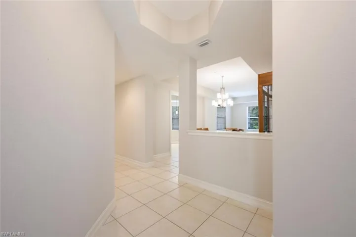Entrance from the front door featuring light tile flooring and a chandelier