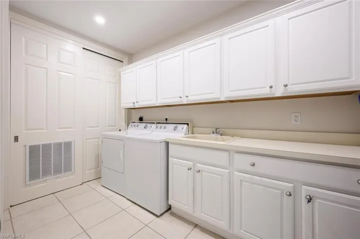 Laundry room with tub sink and plenty of cabinet storage