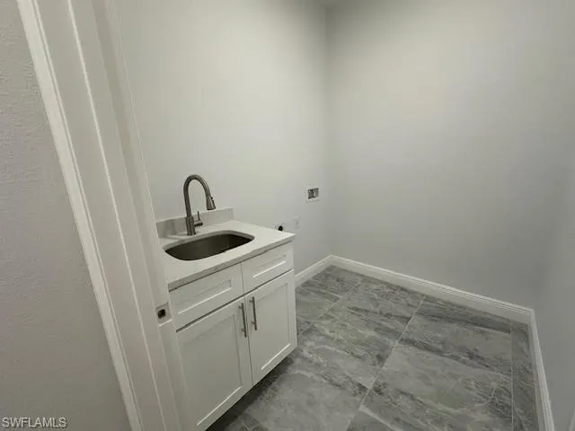 Washroom with washer hookup, cabinets, and sink