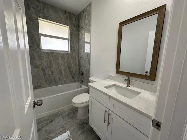 Full bathroom featuring toilet, vanity, and tiled shower / bath